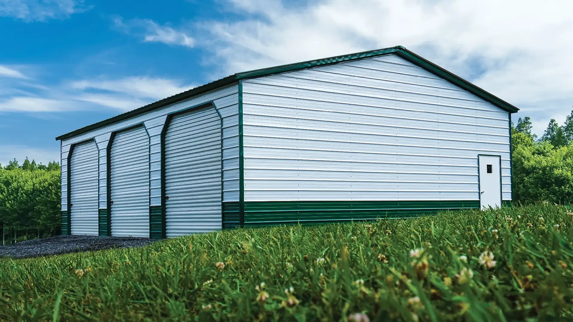 Photo of the Smithy, a 30 by 40 foot steel three-bay shop with white walls and an evergreen roof