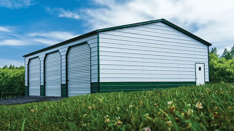 Photo of the Smithy, a 30 by 40 foot steel three-bay shop with white walls and an evergreen roof